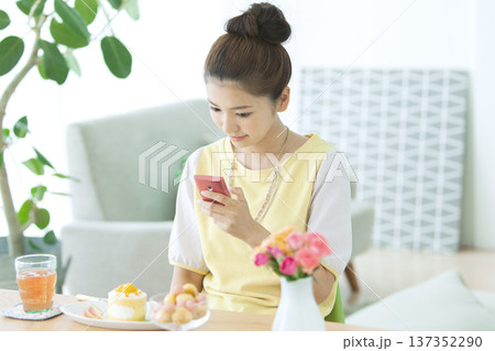 テーブルでスマートフォンを操作する女性 137352290