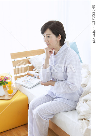ベッドで考え事をする中年女性 ベッドで考え事をする中年女性 137352349