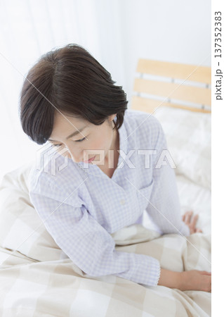 ベッドで座る中年女性 ベッドで座る中年女性 137352383