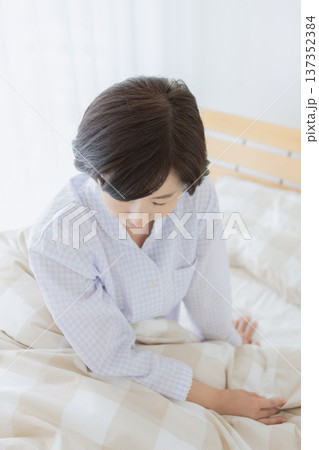 ベッドで座る中年女性 ベッドで座る中年女性 137352384