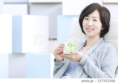 ティーカップを持つ中年女性 ティーカップを持つ中年女性 137352388