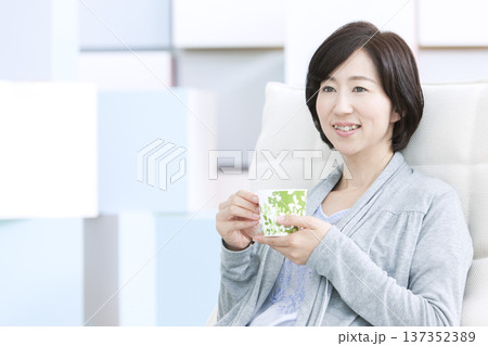 ティーカップを持つ中年女性 137352389