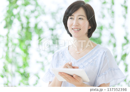 タブレットを操作する中年女性 タブレットを操作する中年女性 137352398