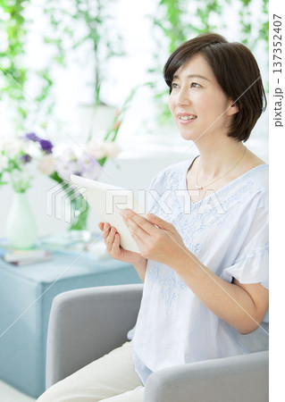タブレットを操作する中年女性 137352407