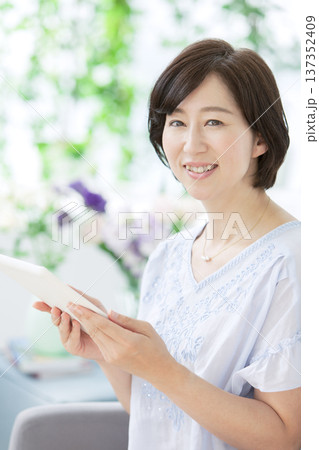タブレットを操作する中年女性 タブレットを操作する中年女性 137352409