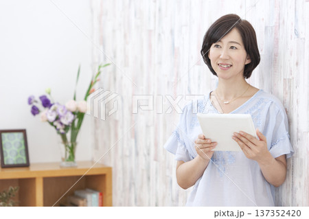 タブレットを操作する中年女性 タブレットを操作する中年女性 137352420
