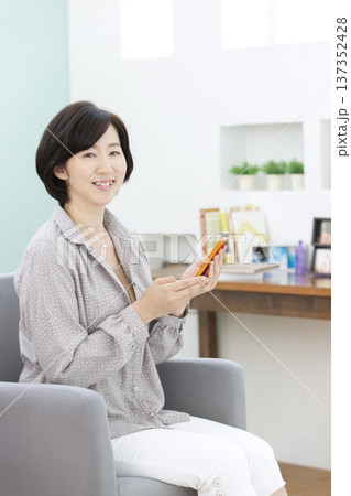 スマートフォンを操作する中年女性 スマートフォンを操作する中年女性 137352428