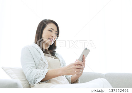 スマートフォンを操作するシニア女性 スマートフォンを操作するシニア女性 137352491