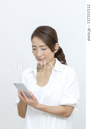 スマートフォンを操作するシニア女性 スマートフォンを操作するシニア女性 137352512