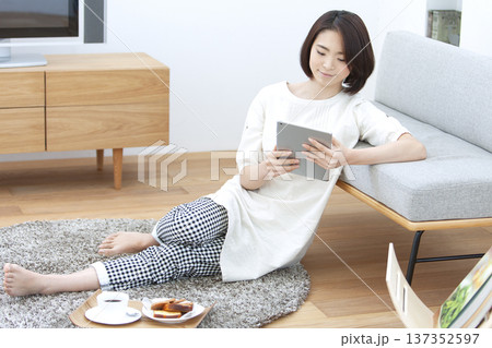 リビングでタブレットを操作する女性 137352597