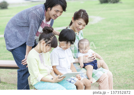 公園でタブレットを操作する家族 公園でタブレットを操作する家族 137352872