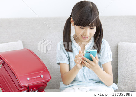 ソファでスマートフォンを操作する女の子 137352993