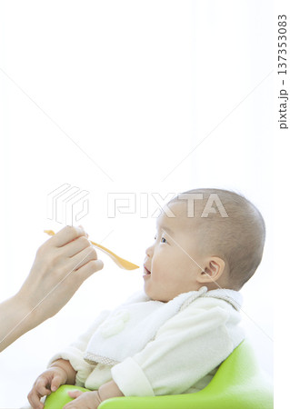 赤ちゃんにご飯を食べさせる母親 赤ちゃんにご飯を食べさせる母親 137353083