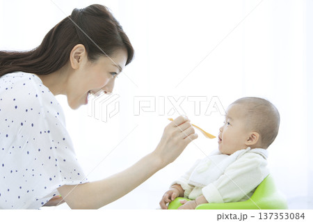 赤ちゃんにご飯を食べさせる母親 137353084