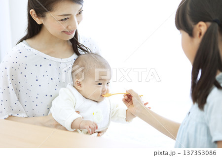 赤ちゃんにご飯を食べさせる女の子 赤ちゃんにご飯を食べさせる女の子 137353086