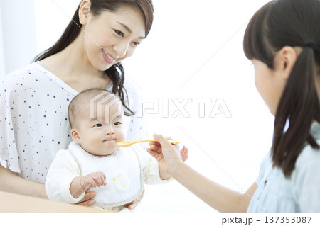 赤ちゃんにご飯を食べさせる女の子 赤ちゃんにご飯を食べさせる女の子 137353087
