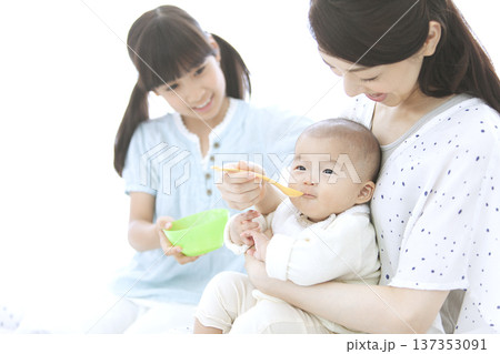 赤ちゃんにご飯を食べさせる母親 赤ちゃんにご飯を食べさせる母親 137353091