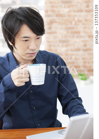 ノートパソコンを操作する男性 137353109