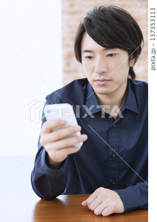 スマートフォンを操作する男性 137353113
