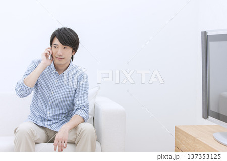 ソファに座って電話をする男性 137353125