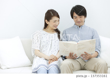 ソファで本を見るカップル 137353161