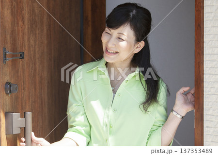 玄関ドアを開ける女性 玄関ドアを開ける女性 137353489