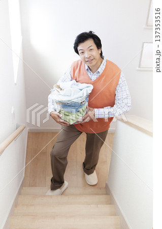 洗濯物を運ぶ男性 137353516