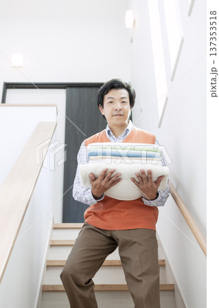 洗濯物を運ぶ男性 洗濯物を運ぶ男性 137353518