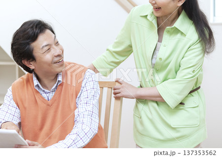 タブレットを見て話す夫婦 タブレットを見て話す夫婦 137353562