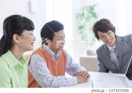 営業マンと打ち合わせをする夫婦 137353569