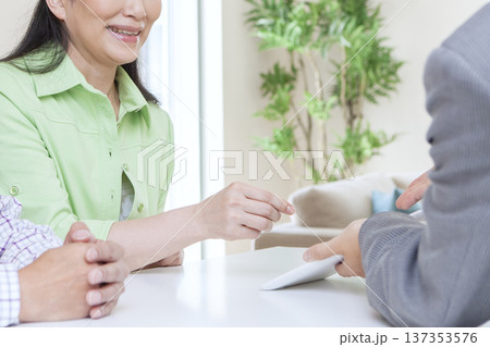 営業マンと打ち合わせをする夫婦 営業マンと打ち合わせをする夫婦 137353576