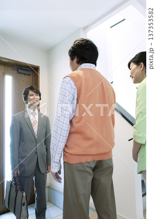営業マンと打ち合わせをする夫婦 137353582