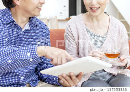 タブレットを見て話す夫婦 タブレットを見て話す夫婦 137353586