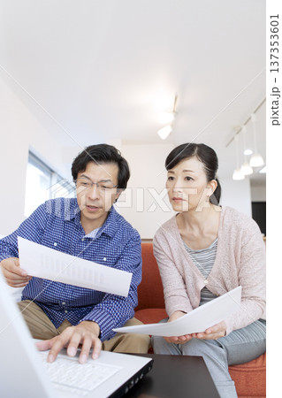 リビングでパソコンを見る夫婦 リビングでパソコンを見る夫婦 137353601
