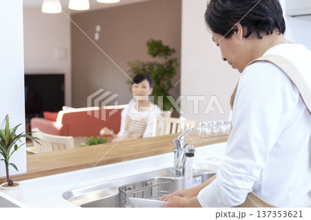 皿洗をする男性と寛ぐ女性 137353621