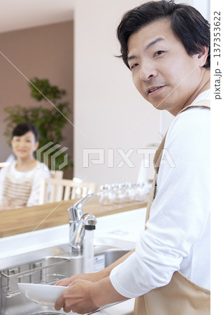 皿洗をする男性と寛ぐ女性 137353622