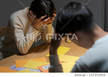 たくさんの請求書に悩む夫婦 137353910