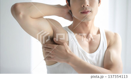 メンズ脱毛・ビフォー　脱毛前の脇のクローズアップ　タンクトップ姿の若い筋肉質な男性　ボディケア・美容 137354113
