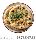 Freshly Baked Indian Bread with Herbs on a White Plate Surrounded by Parsley Sprigs 137354783