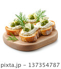 Delicious appetizer platter of toasted bread, creamy cheese, fresh herbs, and green pesto 137354787
