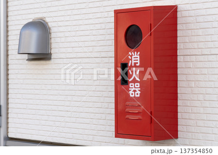 建物の壁に設置された赤い消火器ボックス 建物の壁に設置された赤い消火器ボックス 137354850