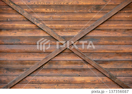 Rustic brown wood paneling creating an X pattern on a barn door texture Rustic brown wood paneling creating an X pattern on a barn door texture 137356087