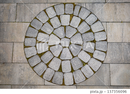 Cobblestone circle pattern forming a design on modern outdoor paving Cobblestone circle pattern forming a design on modern outdoor paving 137356096