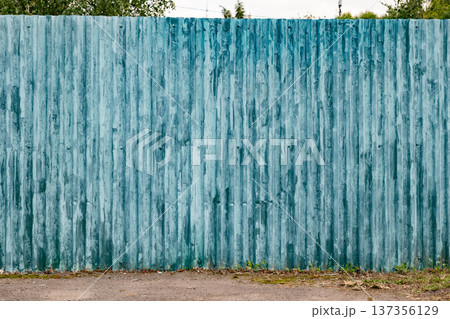 Corrugated metal fence panel with weathered blue paint and rust texture background 137356129