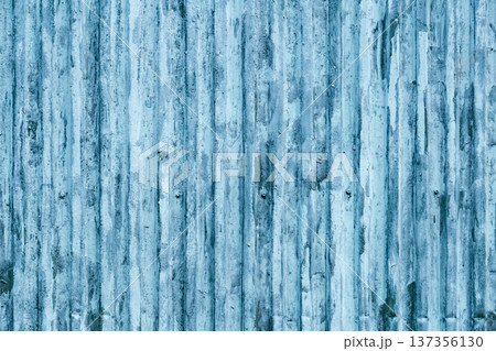 Blue corrugated metal sheet showing weathered surface with rust and peeling paint 137356130