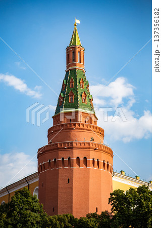 Moscow Kremlin tower with red brick walls and green roof under a blue sky Moscow Kremlin tower with red brick walls and green roof under a blue sky 137356182