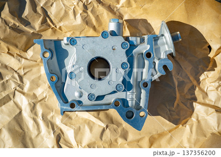 Oil pump housing for automobile engine on crumpled kraft paper, mechanical part Oil pump housing for automobile engine on crumpled kraft paper, mechanical part 137356200