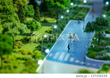 Miniature city planning model with people walking urban streets and green park area Miniature city planning model with people walking urban streets and green park area 137356339