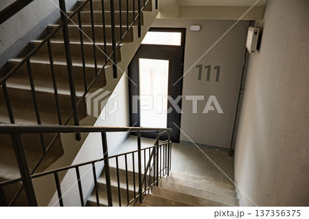 Staircase in a modern building with number 111 next to a door 137356375