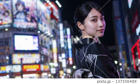 夜の秋葉原でネオンに照らされる黒い着物姿の日本人女性 137356489